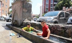 Çankırı'da sıcaklardan bunalan çocuklar serinliği mahalle oluklarında buldu