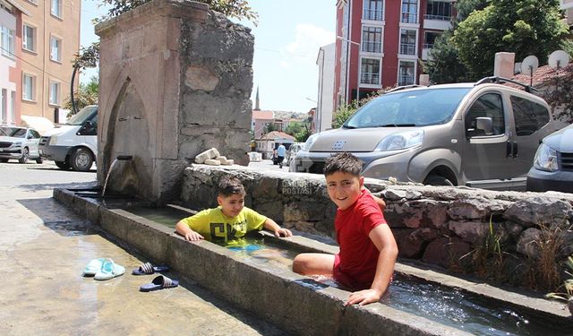 Çankırı'da sıcaklardan bunalan çocuklar serinliği mahalle oluklarında buldu