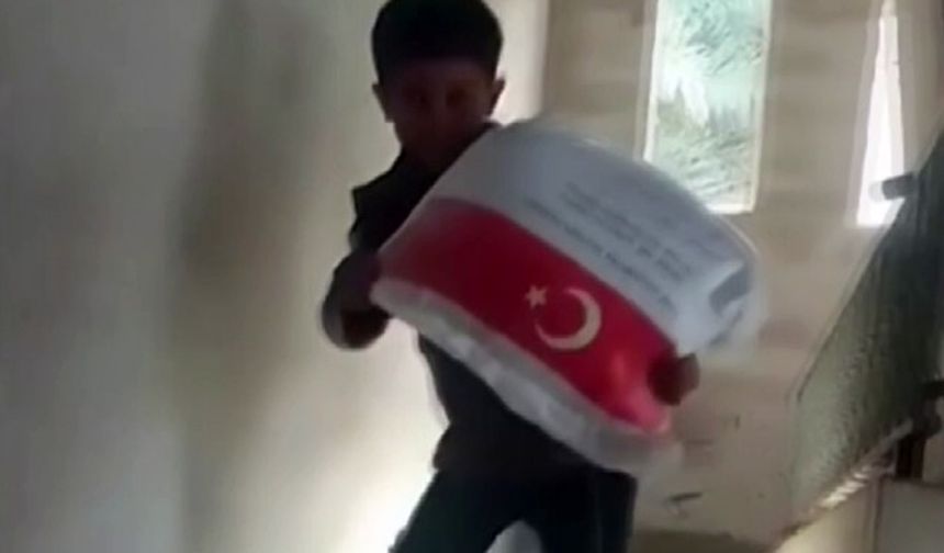 Kendi ağırlığı kadar un çuvalını taşıyan Filistinli çocuğun sevinci